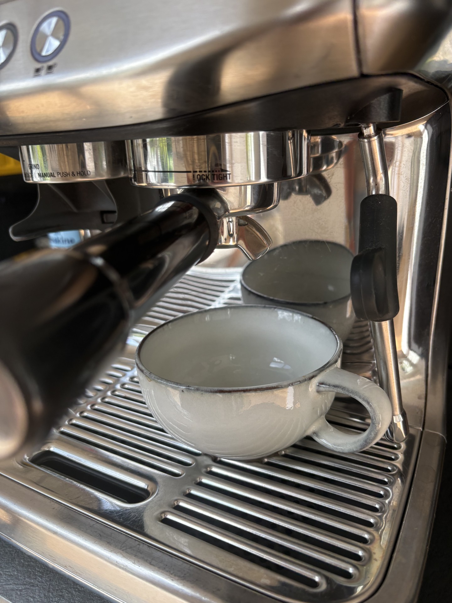 Bryggruppe med portafilter og en tom kop på en Sage Barista Express